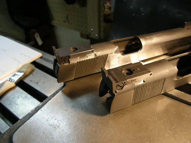Two 1911 pistol slides with rear sight cuts