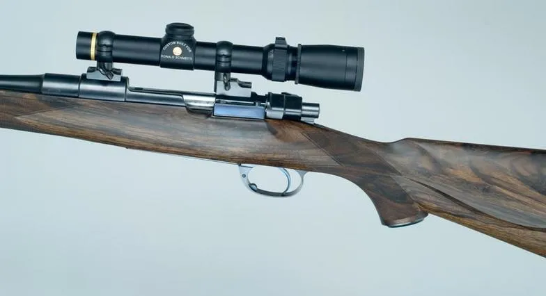 Custom bolt action rifle with figured walnut stock and scope